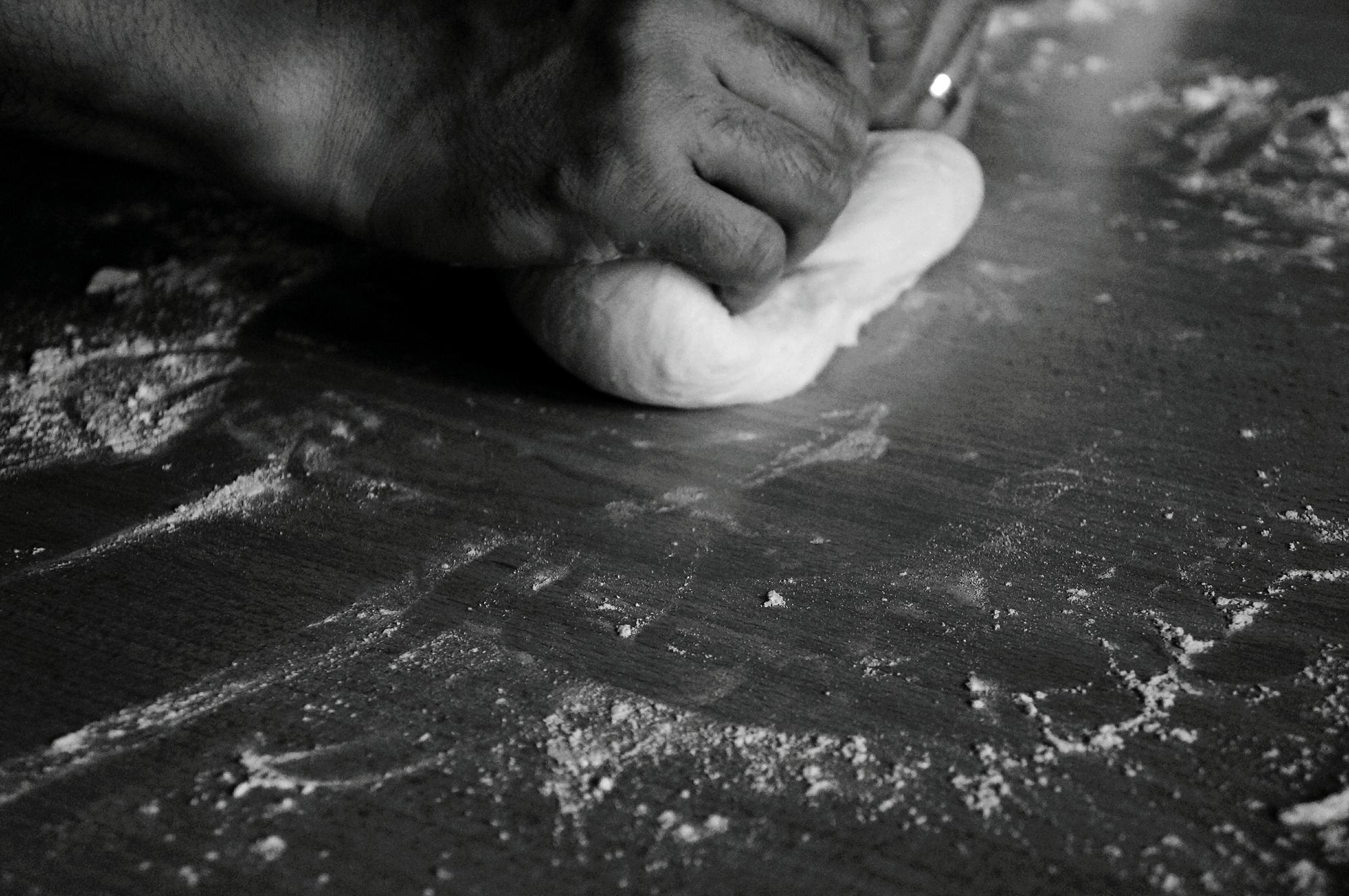 Dettaglio impasto e farina su piano di legno